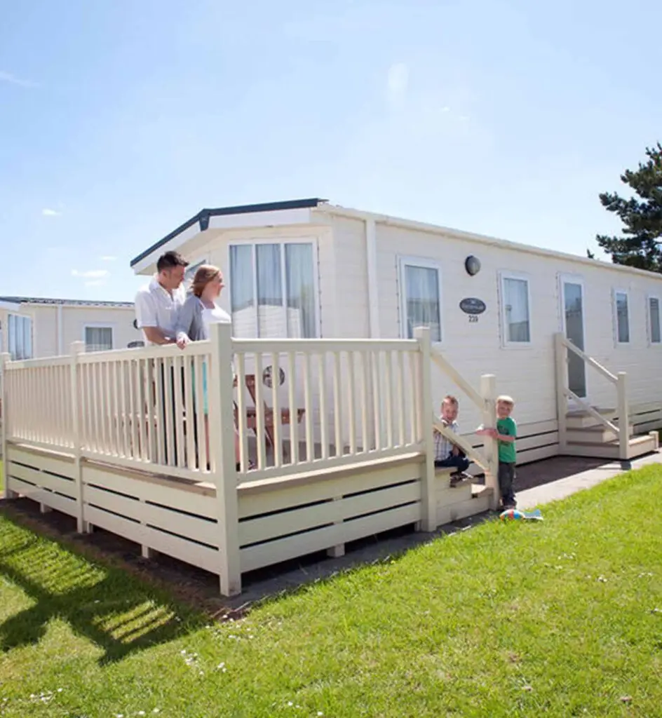 People stood on the decking next to a caravan